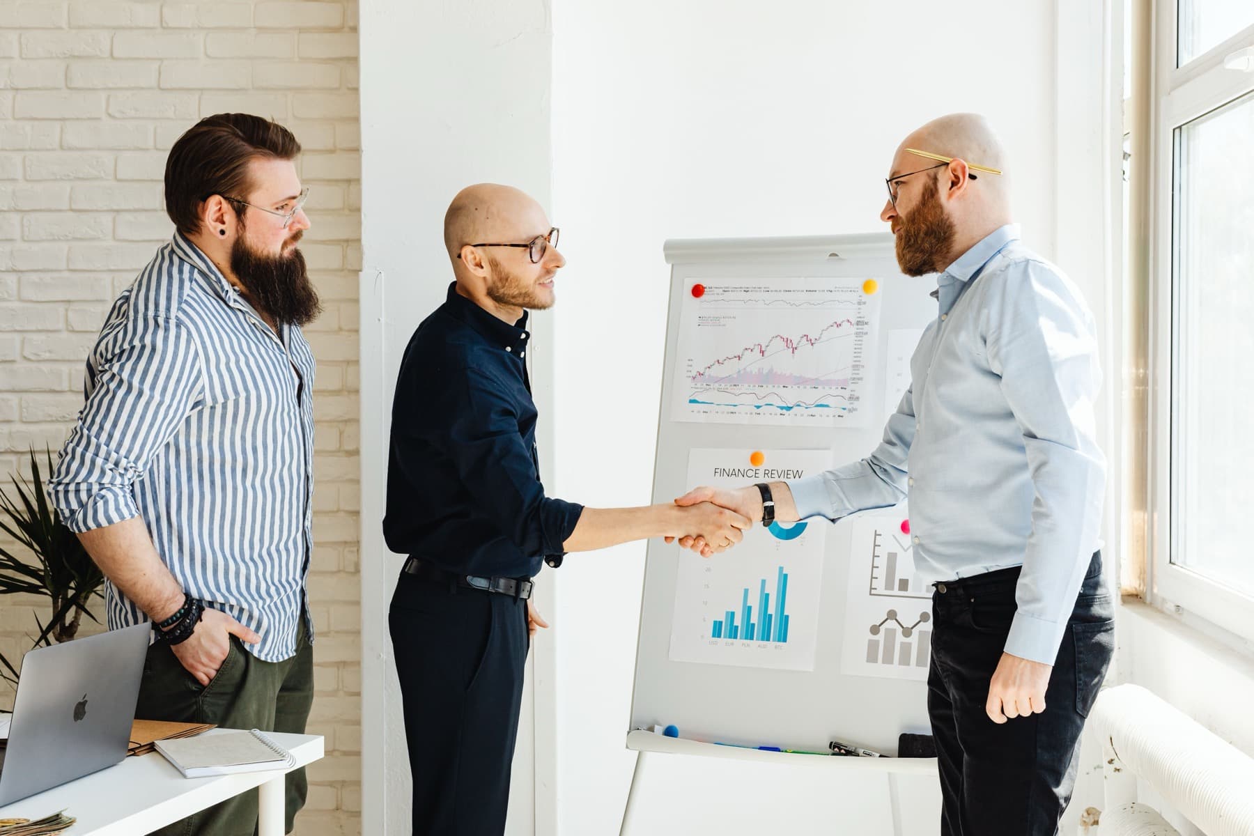Advisors reviewing financial performance and strategy at a whiteboard
