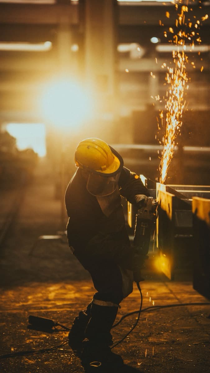 Manufacturing worker welding metal with sparks flying