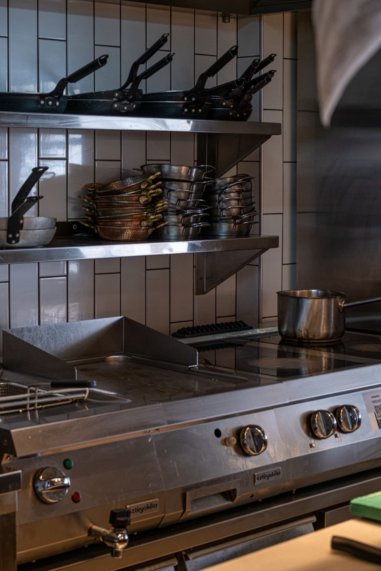 Stainless steel commercial range and cookware in a restaurant