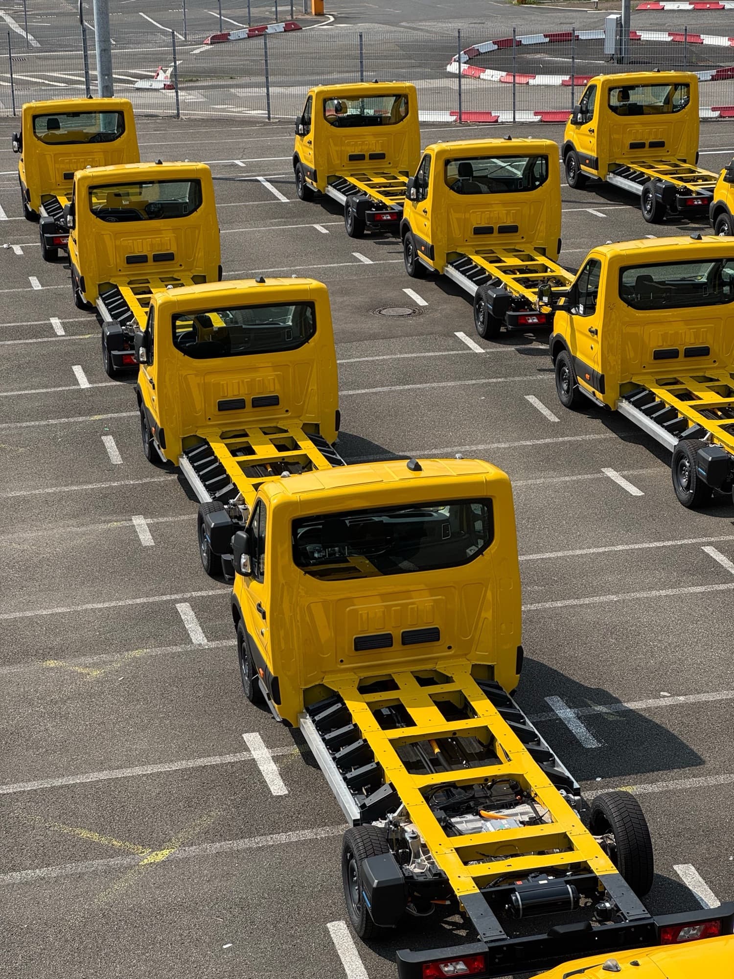 Fleet of new commercial truck chassis lined up in a lot